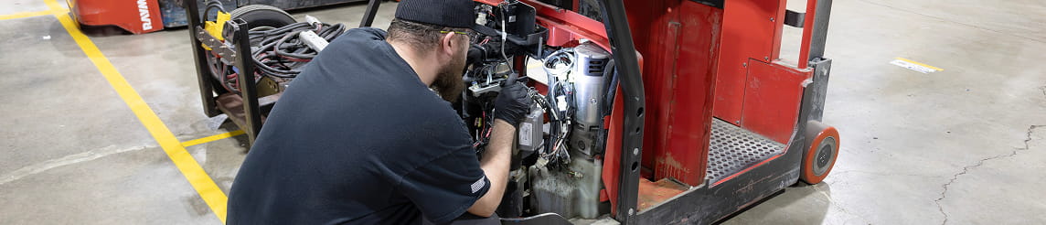 RSC technician inspecting a used Raymond forklift engine in Cincinnati shop.