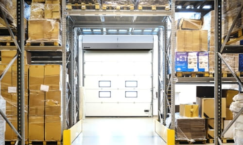 Warehouse aisle featuring an industrial air curtain installed at the loading dock.