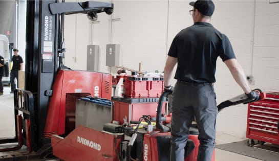 RSC technician performing a battery extraction on a Raymond forklift for fleet maintenance.