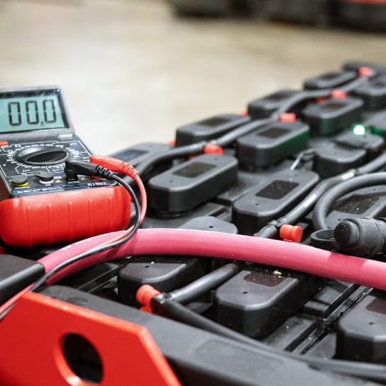 Close-up of an industrial lead-acid forklift battery featuring an integrated diagnostic meter.
