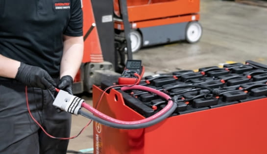 RSC technician testing industrial battery charge levels with a diagnostic meter.