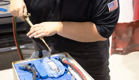 RSC technician repairing a lead-acid battery through welding during a service visit.