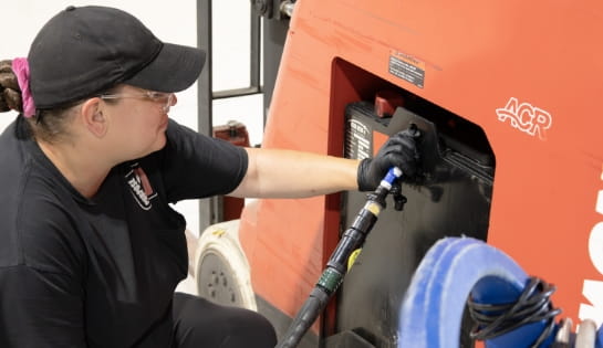 RSC technician watering a lead-acid battery installed in a Raymond forklift.