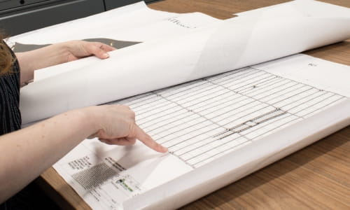 Design engineer reviewing warehouse layouts and facility blueprints.