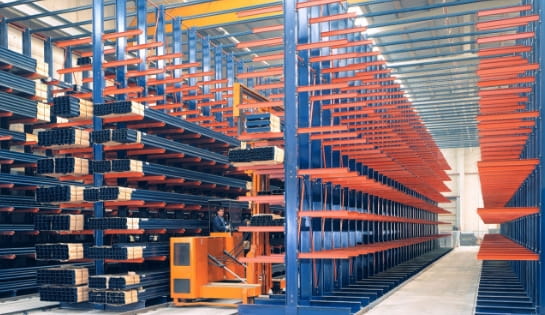 Rows of cantilever storage racks inside a high-density warehouse facility.