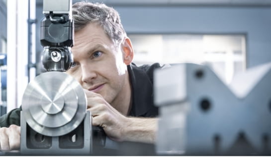 Technician closely inspecting industrial warehouse equipment.