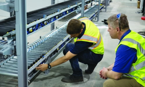RSC project manager reviewing conveyor installation progress with a customer on-site.