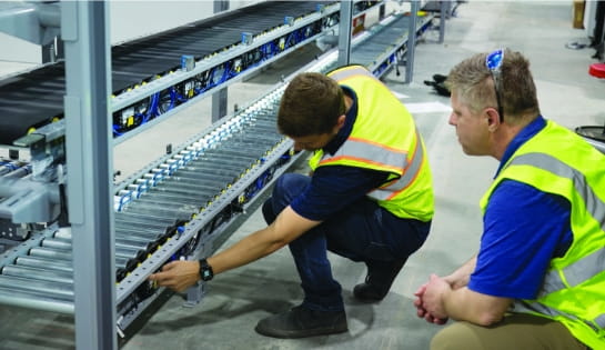 RSC project manager reviewing conveyor installation progress with a customer on-site.