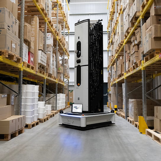 Dexory inventory robot in the middle of warehouse racking aisle.