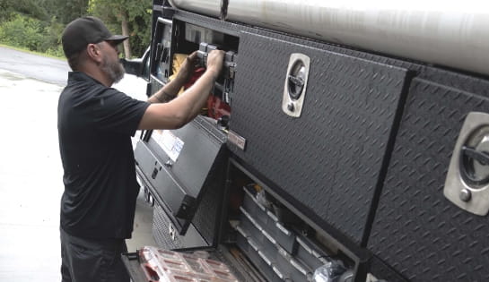 RSC Dock & Door technician retrieving tools from a service truck on-site.