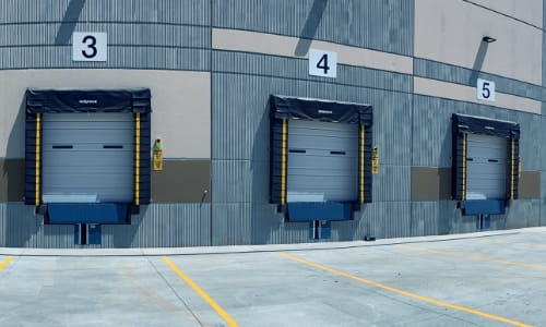 Exterior view of a warehouse facility showing two loading dock doors.