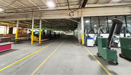 Before photo of the Eckart Supply facility in Blue Ash, OH, showing outdated dock equipment, uneven flooring and dim lighting.