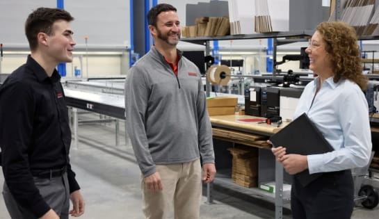 Two Raymond Storage Concepts engineers consulting with a customer in a warehouse picking area.