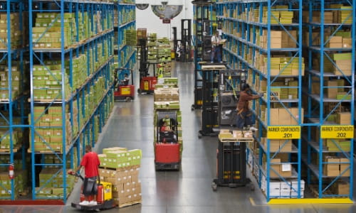 Busy warehouse aisle with several Raymond forklifts navigating racking for order picking