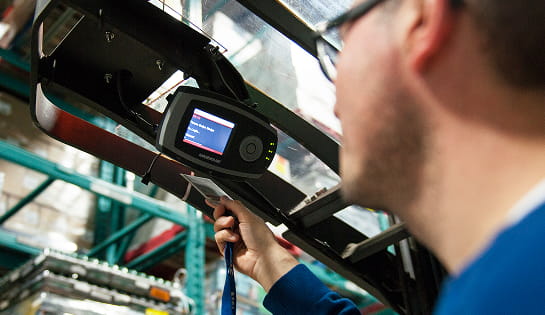 Forklift operator logging into an iWAREHOUSE fleet management monitor.