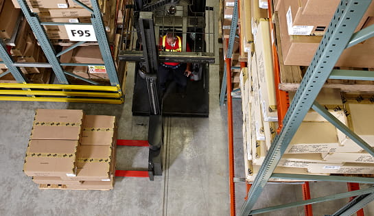 Raymond swing reach truck following a wire guidance in very narrow racking aisle.