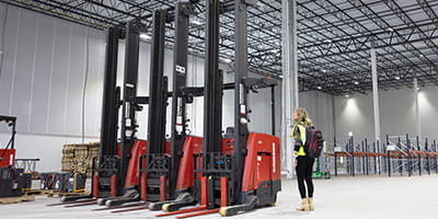 Raymond Storage Concepts account manager reviewing forklift rental arrivals in a remodeled warehouse