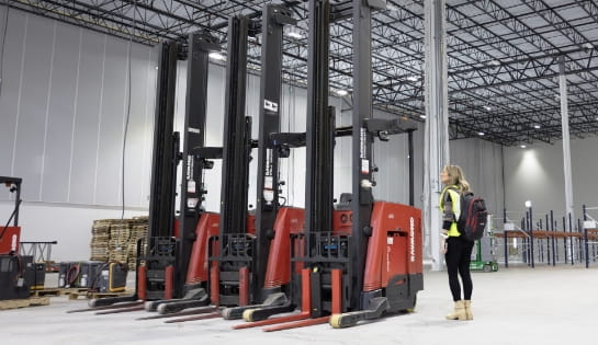 Raymond Storage Concepts account manager reviewing forklift rental arrivals in a remodeled warehouse