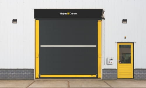 Wayne Dalton high-speed door installed in an interior warehouse wall next to a personnel door