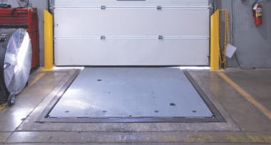 Dock leveler in the horizontal stored position within a warehouse loading area