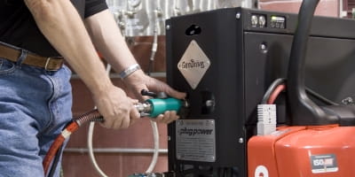 Hands connecting a refueling hose to a hydrogen fuel cell power unit