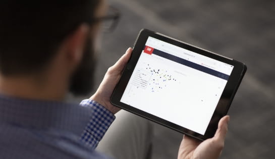 Man viewing the iWAREHOUSE iBATTERY dashboard on a tablet to monitor battery energy usage