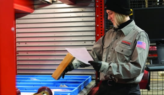 Raymond Storage Concepts employee picking parts based on a work order from an automated storage and retrieval system