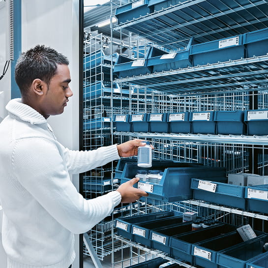 Pharmacist retrieving medication from a horizontal carousel automated storage and retrieval system in a pharmacy