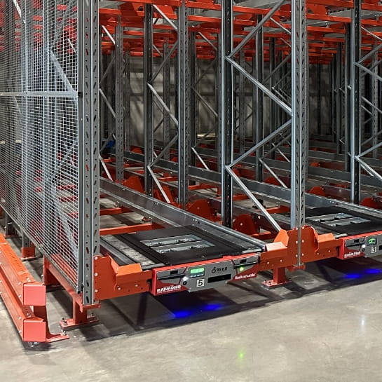 Radioshuttle deep-lane storage handler positioned inside a high-density racking system in a warehouse