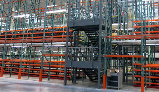 Multi-level pick module featuring pallet racking, mezzanine platforms and industrial stairs installed by Raymond Storage Concepts at a Central Ohio retailer