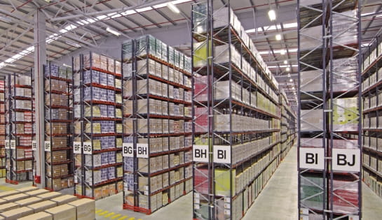 Multiple aisles of industrial warehouse racking fully stocked with pallet cartons