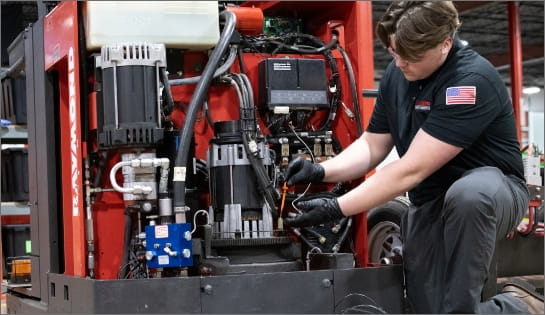 Raymond Storage Concepts technician checking the engine oil of a forklift with its service cover removed