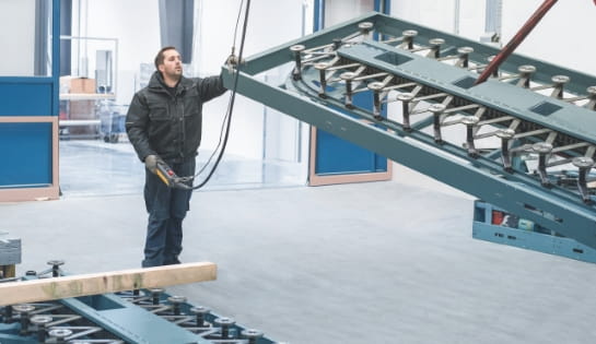 Technician holding a crane controller to operate an automated storage and retrieval system