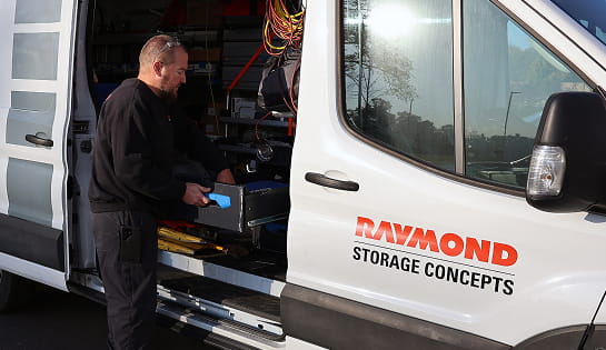 Raymond Storage Concepts technician retrieving tools from a branded service van