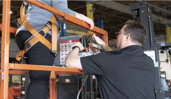 RSC trainer showing a MEWP operator in a safety harness how scissor lift controls work
